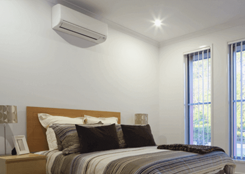 A bedroom featuring a wall mounted air conditioning unit.