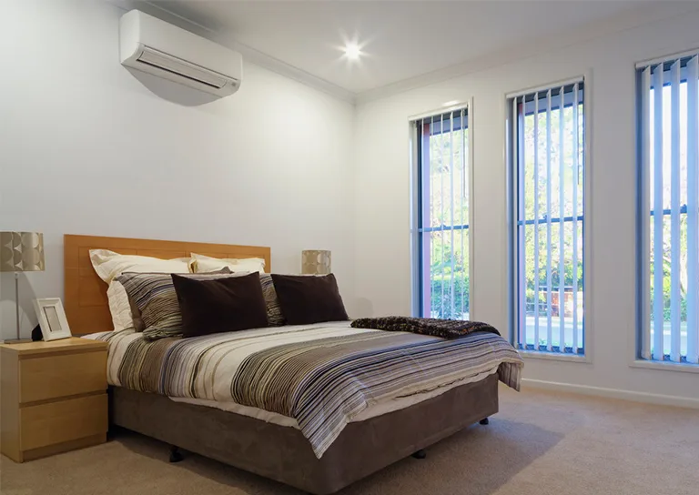 A bedroom featuring a wall mounted air conditioning unit.